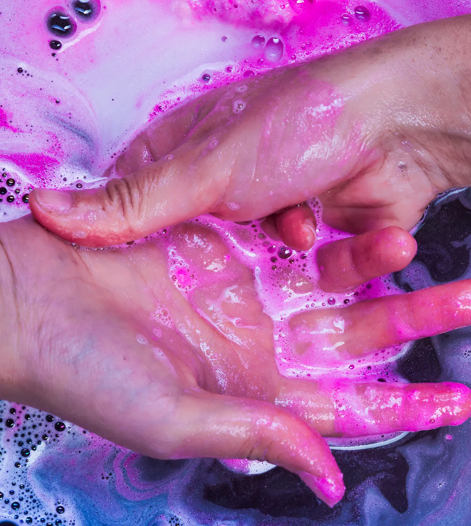 Woman washing her hands in an acrylic removal solution during her Soak-Off Acrylic experience at Pause Spa