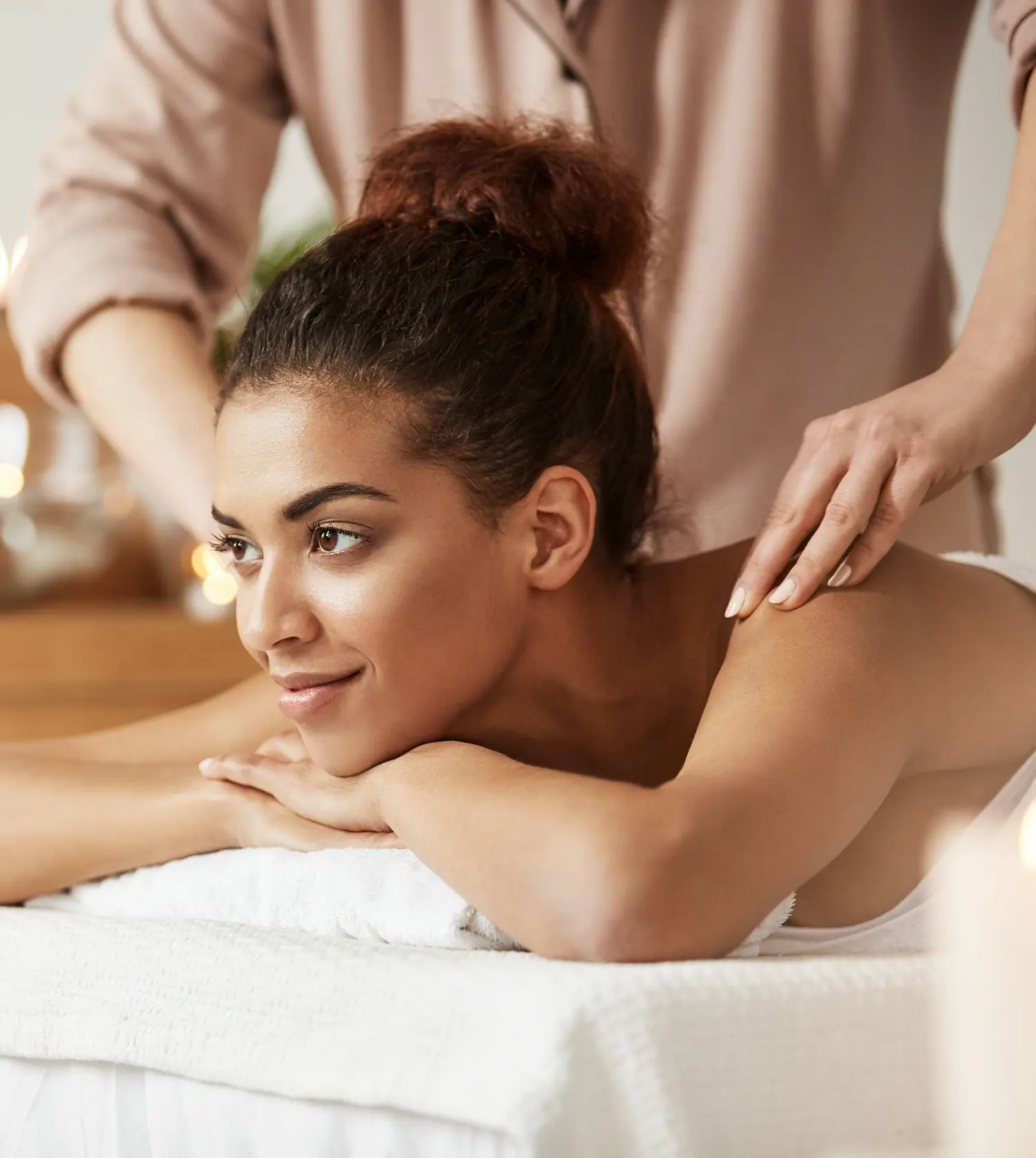 Young African woman enjoying a relaxing back massage during her Unwind Massage experience at Pause Spa